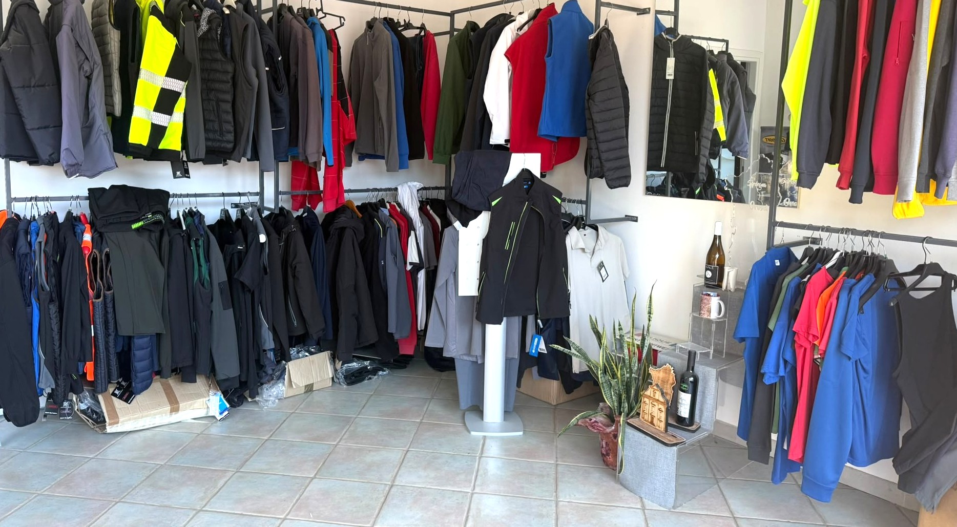 Interno dello showroom Power Of Print esposizione Magliette Felpe Gilet etichette bottiglie e gadget in legno